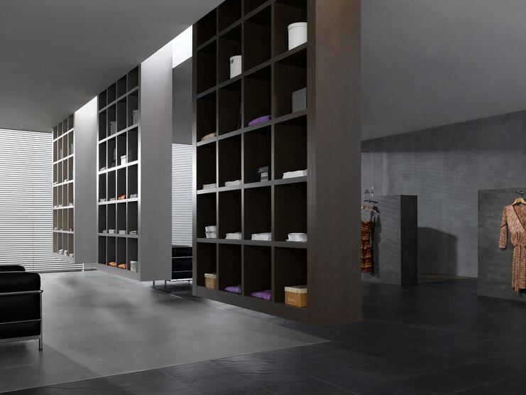 Impression eines geräumigen Regalsystems aus dunklem Holz in einem hochwertigen Bekleidungsladen