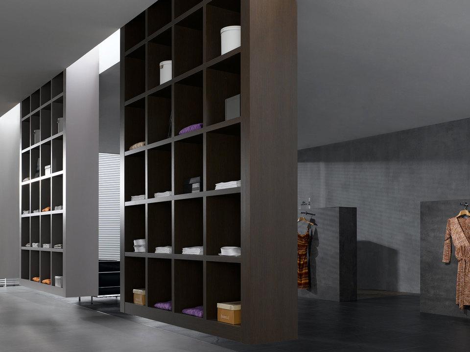 Impression eines geräumigen Regalsystems aus dunklem Holz in einem hochwertigen Bekleidungsladen